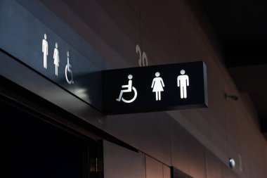 Siyah bir tabaktan çıkan beyaz bir tuvalet aydınlanmasının işareti. Tuvalet bir binanın içinde, siyah beyaz tonda dekore edilmiş..