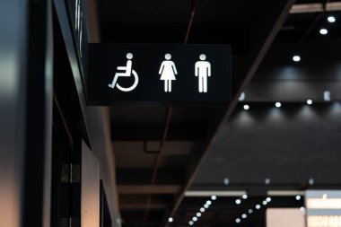 Siyah bir tabaktan çıkan beyaz bir tuvalet aydınlanmasının işareti. Tuvalet bir binanın içinde, siyah beyaz tonda dekore edilmiş..