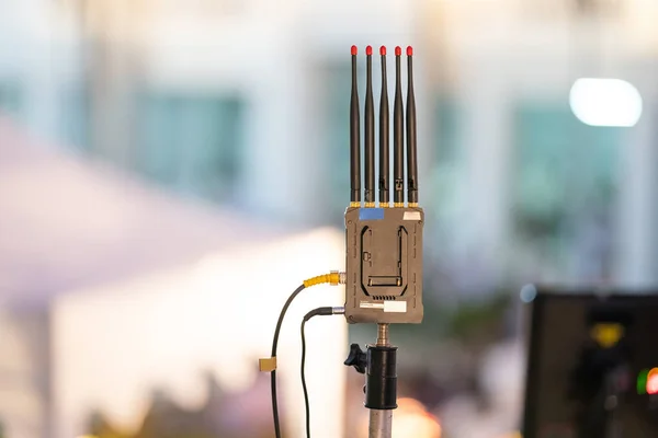 Live broadcast antenna is located outdoors at night that background is blurred lights.