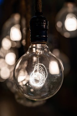 Karanlık bölgede iple asılı klasik Tungsten Lambası grubuna yaklaş..