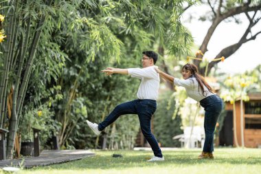 Asyalı Kadın, erkeği omuzundan tutup onunla yaşaması için destekliyor..