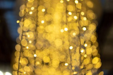 Kutlama kartı için koyu arkaplanda sarı parıltı bulanıklaşır ve bulanıklaşır..