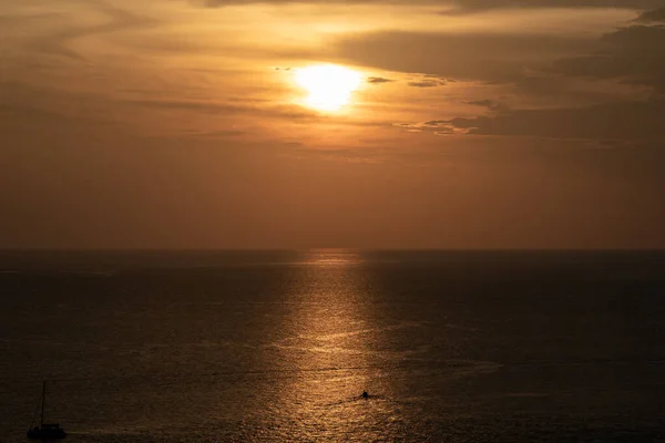 Sunset on the sea and through the clouds over. Tranquil seascape with the horizonal skyline.