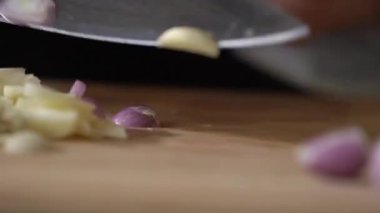 Shallot dilimlemek, ahşap bir tahtanın üzerinde kırmızı soğan dilimlemek profesyonel bir aşçının mutfak bıçağıyla..