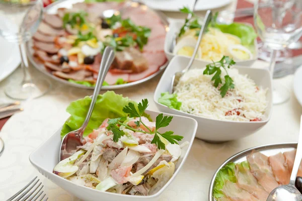 Elegante tabel instelling in restaurant met gerechten vol van voedsel voor viering — Stockfoto