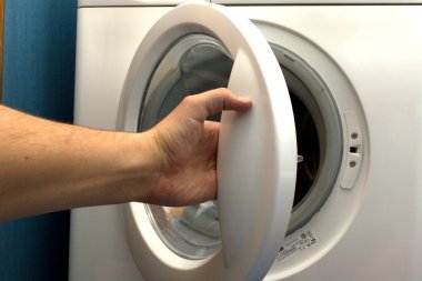 Man opening washing machine in bathroom clipart