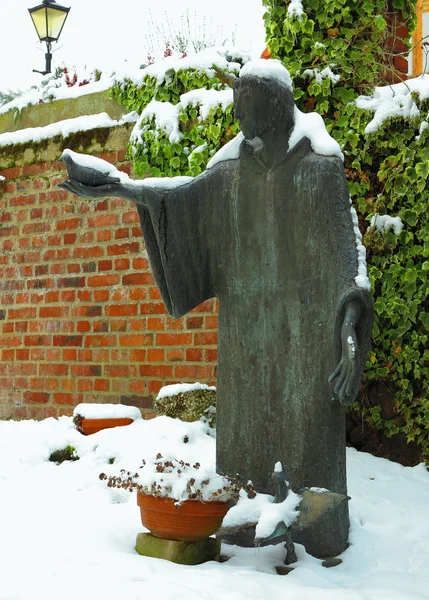 Schneebedeckte Steinskulptur des Heiligen Franziskus — Stockfoto