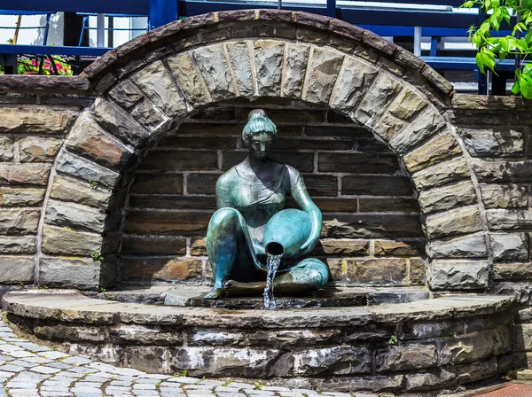 Härlig kvinna skulptur vid byn väl — Stockfoto