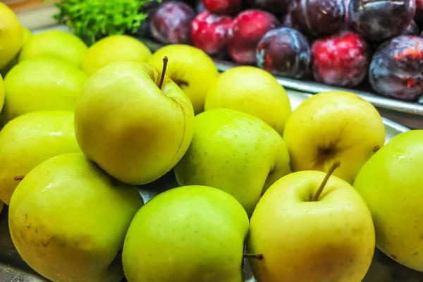 Yellow apples and violet nectarines — Stock Photo, Image