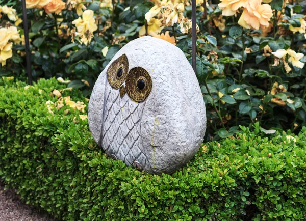 バラ園にフクロウ彫刻 — ストック写真