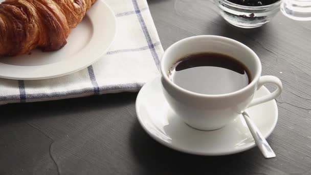 把咖啡奶油倒入一杯黑咖啡中.法国羊角面包和一杯咖啡。甜甜的早餐食物 — 图库视频影像