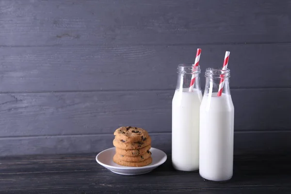 Leche y galletas sobre un fondo de madera gris con lugar para el texto. Leche y galletas para Santa Claus para Navidad — Foto de Stock