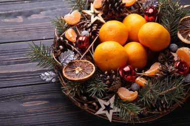Noel çelengi çam kozalakları, oyuncaklar ve mandalinalarla süslenmiştir..