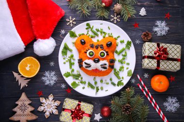 Kaplan 2022 'nin sembolüdür. Ahşap arka planda kaplan salatası. Noel kompozisyonu.