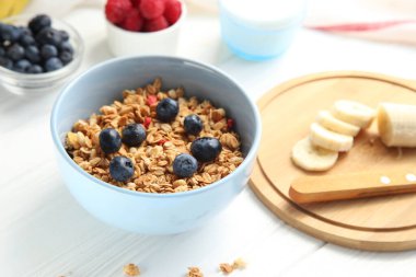 Beyaz arka planda meyveli granola. Ahududu, yaban mersini ve muzlu granola..