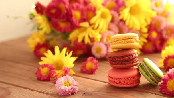 Macaroons on a wooden background. Girl picks up macarons — Video