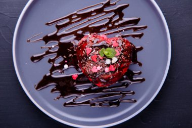 Kek, arka planda naneli ve çikolatalı kalp şeklinde. Sevgililer Günü. Üst görünüm