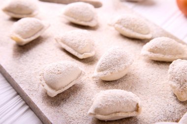 Beyaz ahşap arka planda lahanalı çiğ hamur tatlısı. Vareniki bir Slav mutfağıdır.