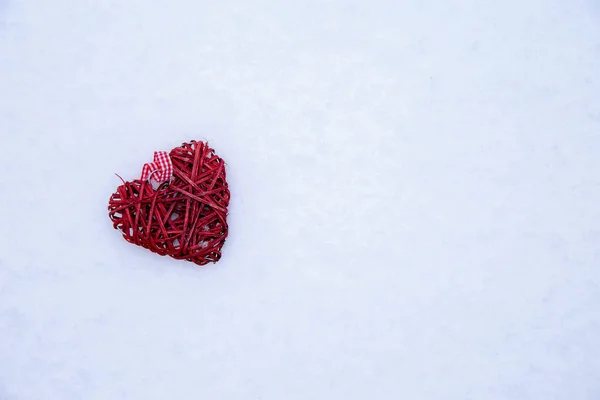 在雪地里，一颗柳条红色的心，上面有文字 — 图库照片