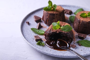 Gri arka planda çikolata fontajlı kompozisyon. Naneyle süslenmiş..