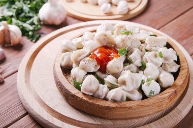 Ahşap arka planda domates soslu ve otlu hamur tatlısı.