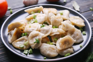 Siyah tabakta patates ve soğanlı Vareniki.