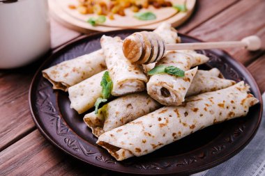 Süzme peynirli krep, kuru üzüm ve bal ahşap arka planda..