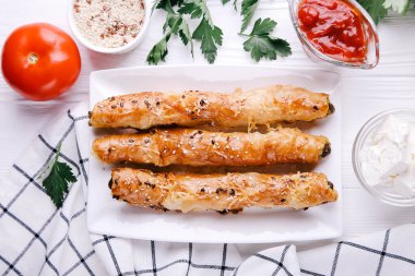 Rollini with meat with sauce and sesame seeds on a white background. Top view