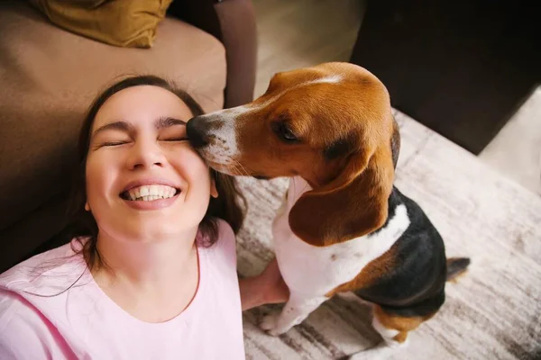 A dog kisses a woman.