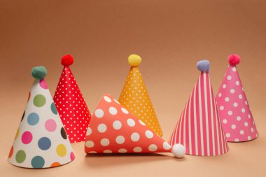 Kahverengi arka planda renkli bir doğum günü şapkası. Boşluğu kopyala. 