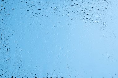 Su damlaları olan mavi bir sırt sırtı. Islak cam. Boşluğu kopyala. 