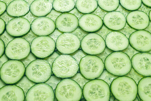 Fresh green slices of cucumber as background. Top view. 