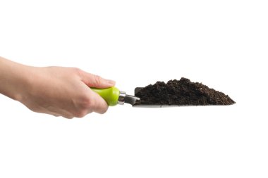 Kadında toprak olan küçük yeşil kürek beyaz arka planda izole edilmiş..  