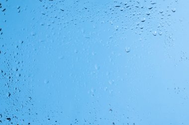 Su damlaları olan mavi bir sırt sırtı. Islak cam. Boşluğu kopyala. 
