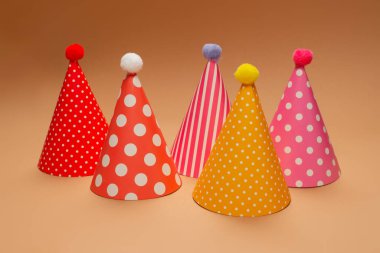 Kahverengi arka planda renkli bir doğum günü şapkası. Boşluğu kopyala. 