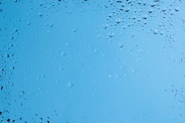 Su damlaları olan mavi bir sırt sırtı. Islak cam. Boşluğu kopyala. 