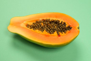 Yeşil arka planda kadın ellerinde Papaya meyvesi. Tropik meyve. Yarım papaya.. 