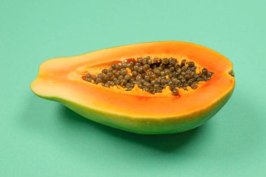 Yeşil arka planda kadın ellerinde Papaya meyvesi. Tropik meyve. Yarım papaya.. 