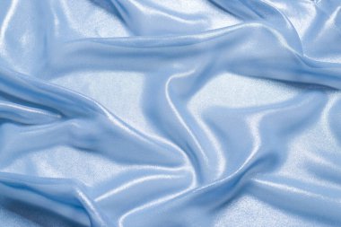 Arka plan olarak mavi parlak inci kumaş. Üst görünüm. 