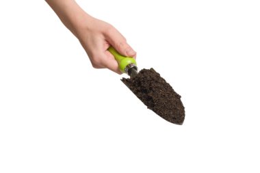 Kadında toprak olan küçük yeşil kürek beyaz arka planda izole edilmiş..  