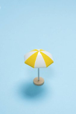 Mavi arka planda sarı şemsiye. Boşluğu kopyala.