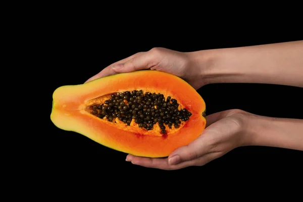 女性の手の中に黒い背景に隔離されたパパイヤの果実 熱帯果実 半パパイヤ — ストック写真