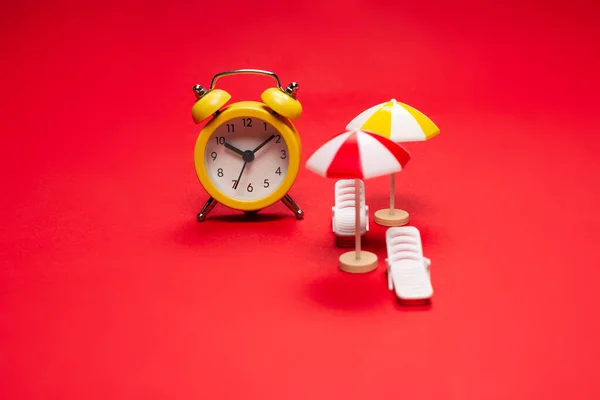 Tijd Reizen Ligstoel Parasol Wekker Een Rode Achtergrond — Stockfoto
