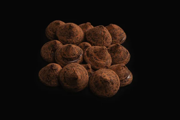 Chocolate truffles on a black background. Chocolate candies.