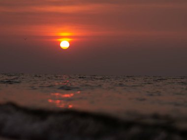 Sahilde güzel bir gün batımı. Yaz günbatımı ve deniz dalgaları