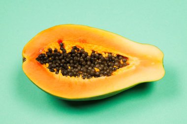 Yeşil arka planda kadın ellerinde Papaya meyvesi. Tropik meyve. Yarım papaya.. 