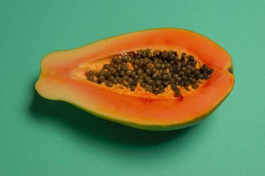Yeşil arka planda kadın ellerinde Papaya meyvesi. Tropik meyve. Yarım papaya.. 