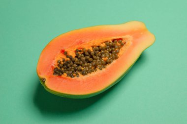 Yeşil arka planda kadın ellerinde Papaya meyvesi. Tropik meyve. Yarım papaya.. 