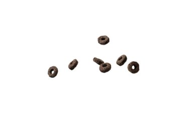 Çikolata halkaları gevrekleri bir kaseye dökülür. Kahvaltıda. Beyaz bir arkaplanda izole edilmiş. 