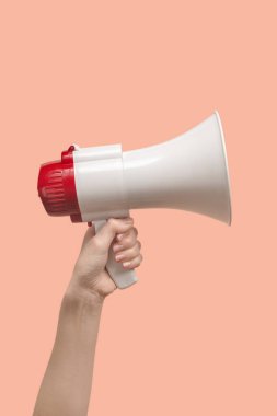 Pembe arka planda kadın eli olan megafon. Boşluğu kopyala.